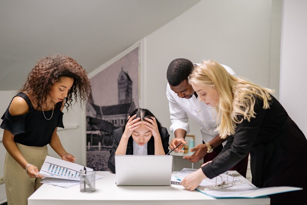 Person experiencing social anxiety at work sitting stressed at office desk